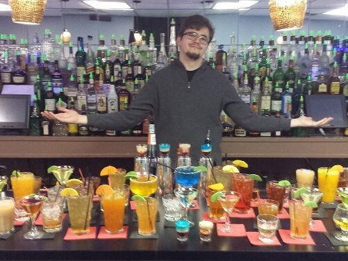 Instructor behind bar with a row of drinks